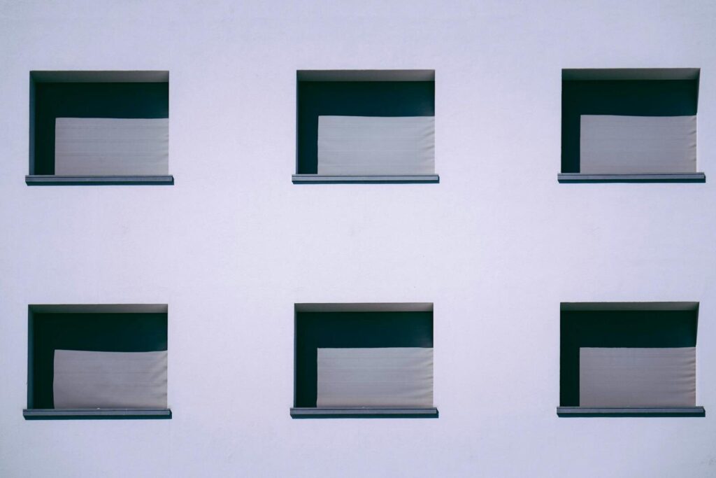 Symmetrical facade with six square windows creating geometric design on a modern building.