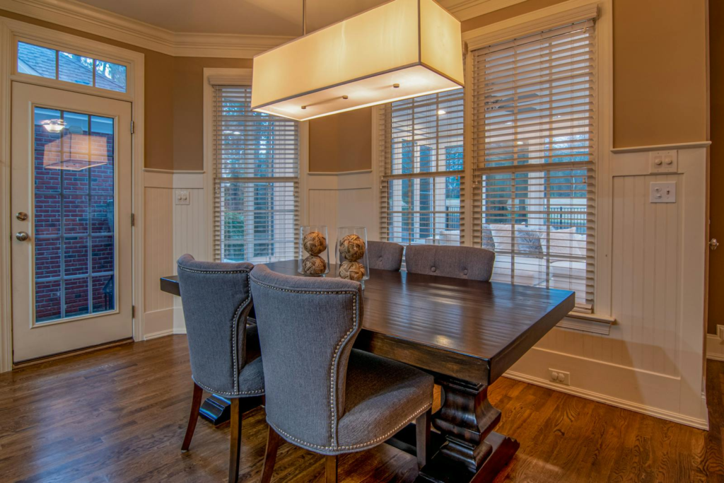 Stylish dining room showcasing modern furniture, elegant lighting, and beautiful natural light through large windows.
