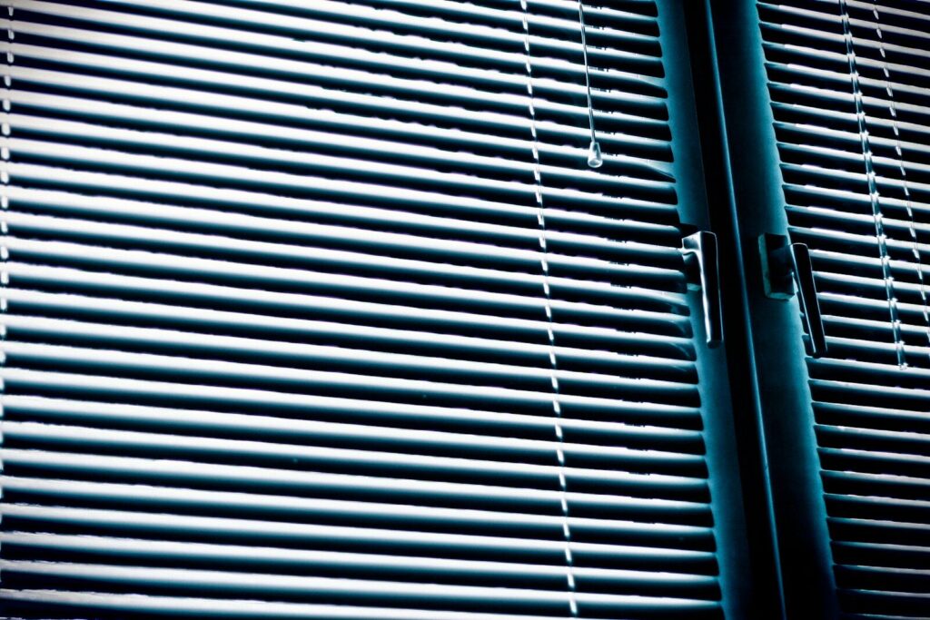 macro photography of white window blinds