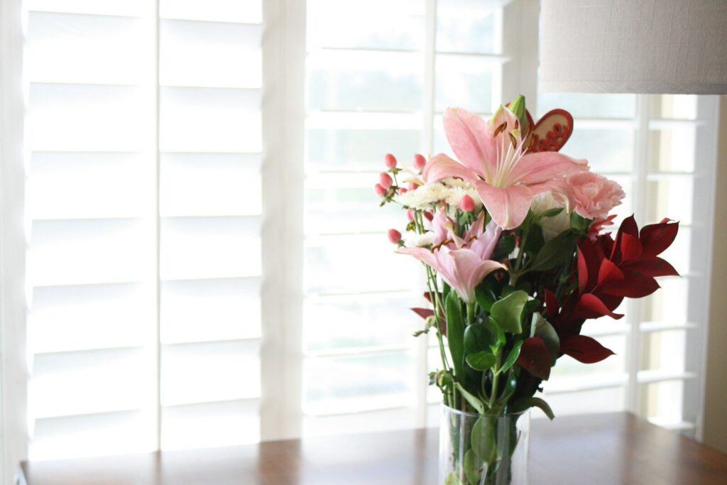 a vase filled with pink and white flowers on a table